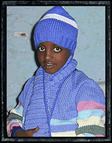 Child in Ethiopia wearing knitted goods brough by Jack & Jane Verburg